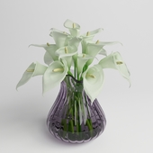 calla lily arrangement in colored  glass vase
