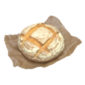 Круглая булка хлеба на вощеной бумаге