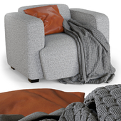 Armchair with decorative pillow and knitted blanket