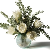 Bouquet with white proteas and eucalyptus in a ribbed glass vase