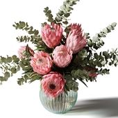 Bouquet with pink proteas and eucalyptus in a ribbed glass vase