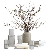 Decorative set with a bouquet of branches, books and a decanter with glasses